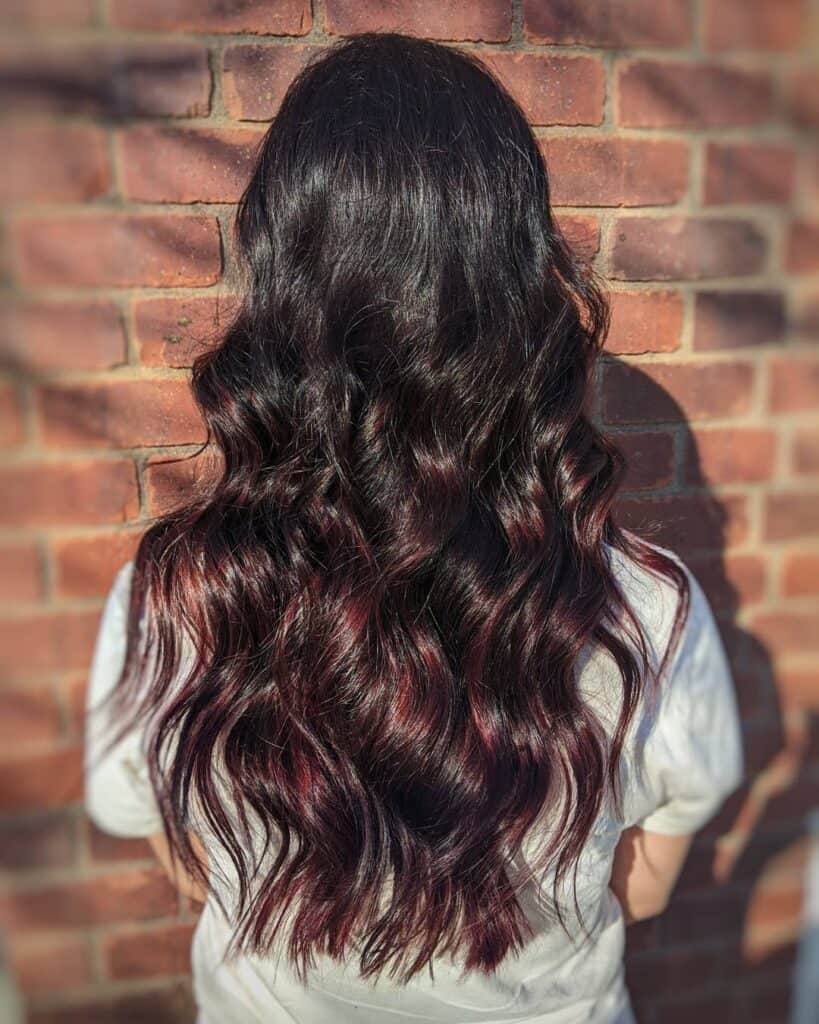 cherry cola highlights on long hair with soft waves