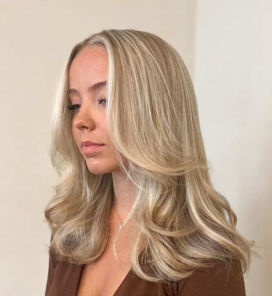 wispy face framing layers on medium blonde hair